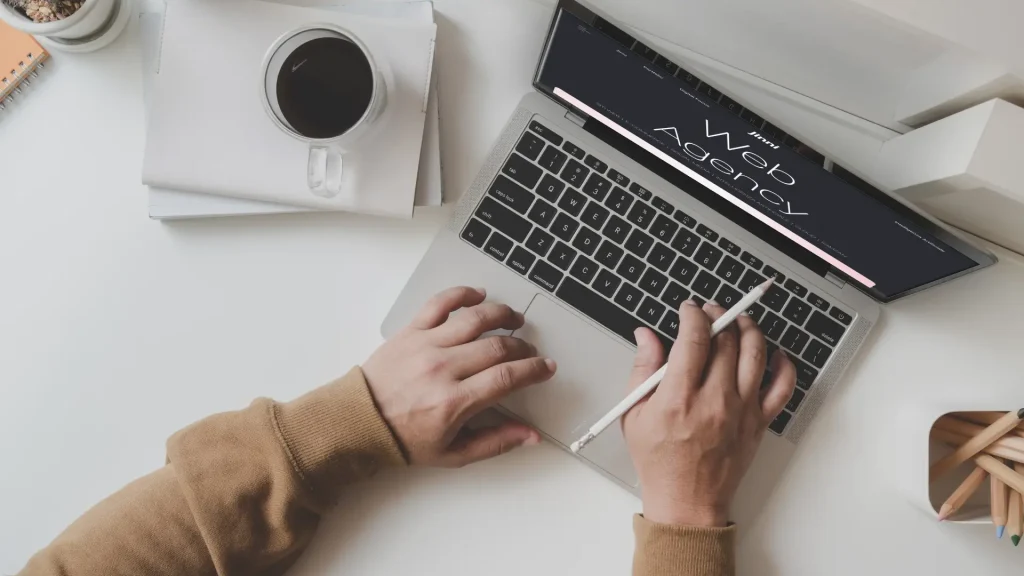 Man working on a laptop with the word "Web Agency" on the screen for the article dedicated to solutions to improve website performance.