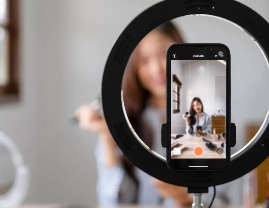Influencerin nimmt mit einem auf einem Ringlicht montierten Smartphone ein Video auf, für den Content-Marketing-Service der Digital Agency Jinni S.r.l.