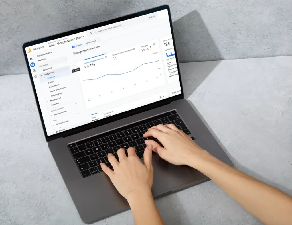 Hände, die auf einem Laptop tippen, auf dessen Bildschirm Google Analytics geöffnet ist, für den Service der Digital Agency Jinni S.r.l.