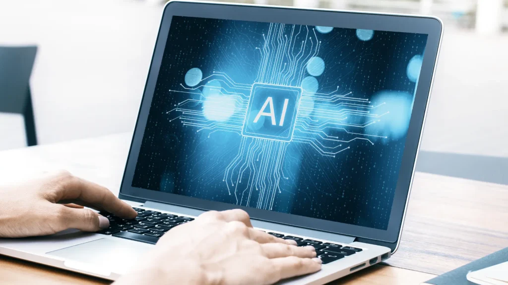 双手在笔记本电脑上打字，屏幕上显示“AI”图案，AI Focus 文章配图，用于解释什么是人工智能