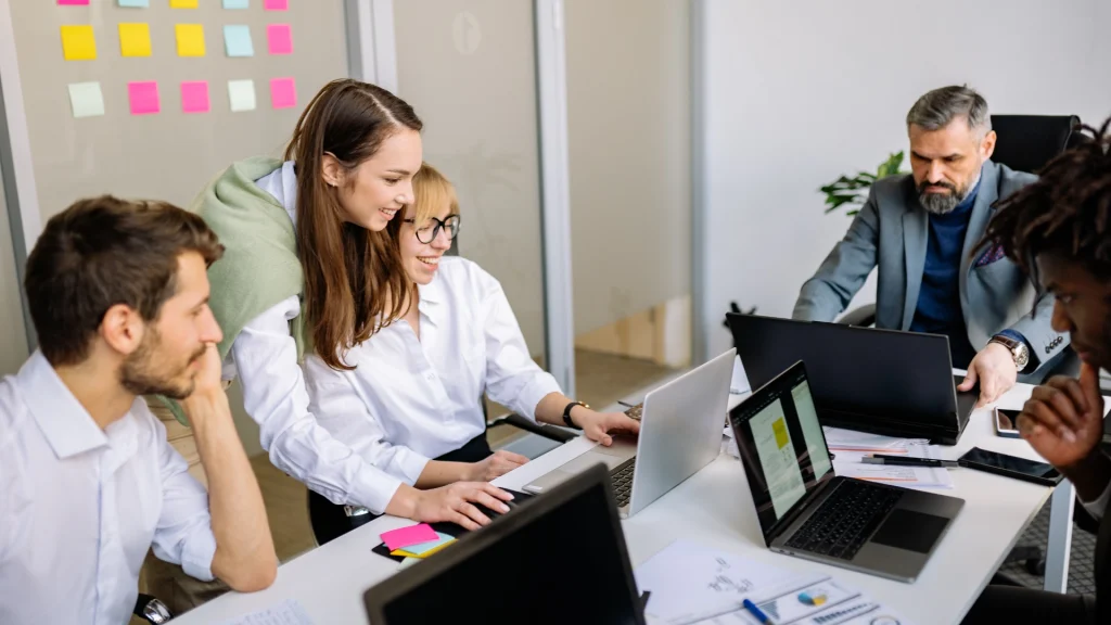 Work team collaborate in front of laptops in modern office