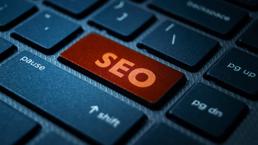 Rot hervorgehobene SEO-Taste auf einer schwarzen Tastatur, Symbol für Suchmaschinenoptimierung im modernen digitalen Kontext