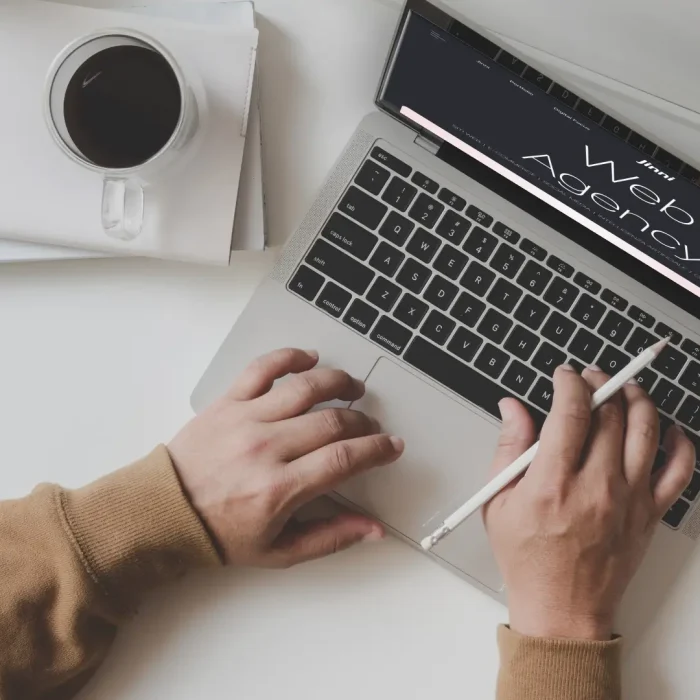 Uomo che lavora su un laptop con la scritta "Web Agency" sullo schermo per l'articolo dedicato alle soluzioni per migliorare le prestazioni del sito web.