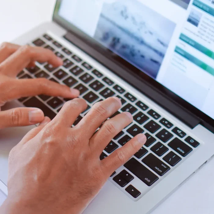 Mani maschili che digitano su un laptop che scrivono contenuti per il web