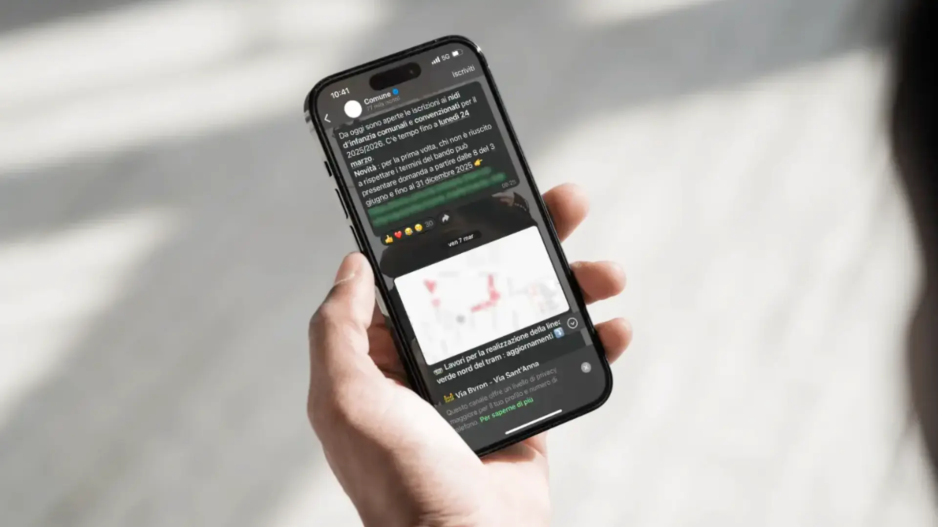Hand holding a smartphone with an information message from the municipality on telegram or WhatsApp channel.
